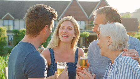Parents With Adult Offspring Enjoying Outdoor Summer Drink At Pubの写真素材
