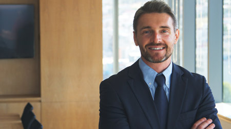 Portrait Of Smiling Businessman Wearing Shirt And Tie Standing In Modern Officeの写真素材