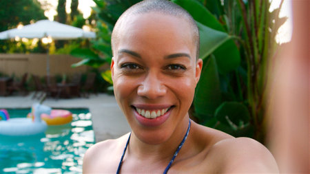 Portrait Of African American Woman With Shaved Head Outdoors With Friends Enjoying Summer Pool Party