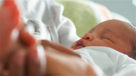 Close Up Of Mother Holding Sleeping Newborn Baby In Nursery At Homeの写真素材