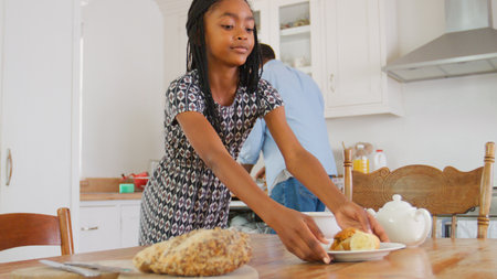 Father And Daughter Preparing Family Breakfast In Kitchen At Hone