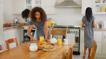 Family With Teenage Children Preparing Breakfast In Kitchenの写真素材
