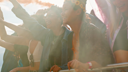 Audience With Colored Smoke Behind Barrier Dancing And Singing At Outdoor Festival Enjoying Music