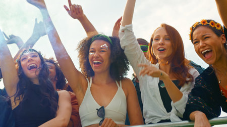 Group Of Female Friends In Audience Behind Barrier Dancing And Singing At Festival Enjoying Music