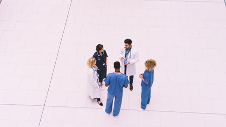 Overhead View Of Medical Staff Having Informal Meeting In Lobby Of Modern Hospital Buildingの写真素材
