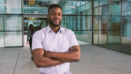 Portrait Of Smiling Businessman Standing In Lobby Of Busy Modern Office