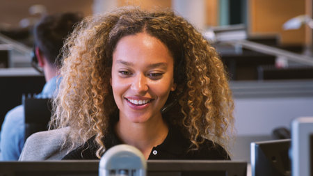 Young Businesswoman Wearing Telephone Headset Working In Customer Services Department