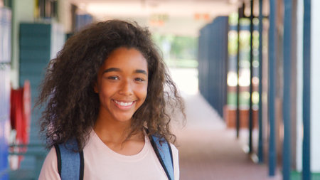 Portrait Of Smiling Female High School Student Standing Outside College Buildingの写真素材