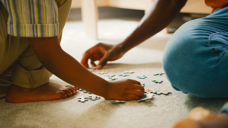 Close Up Of Parent And Child At Home Doing Jigsaw Puzzle Togetherの写真素材