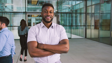 Portrait Of Smiling Businessman Standing In Lobby Of Busy Modern Officeの写真素材