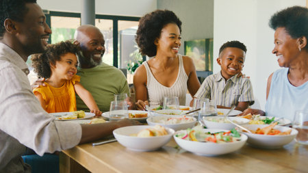 Multi-Generation Family Sitting Around Table Eating Meal At Home Togetherの写真素材