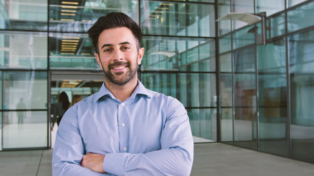 Portrait Of Smiling Businessman Standing In Lobby Of Busy Modern Officeの写真素材