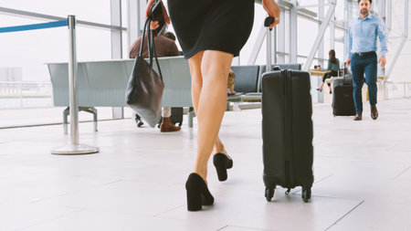 Close Up Of Legs Of Businesswoman With Luggage In Busy Airport Departure Loungeの写真素材