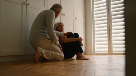 Depressed Senior Woman Suffering With Poor Mental Health Being Comforted By Husband At Homeの写真素材