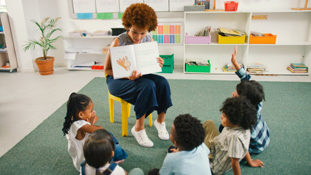 Female Teacher Reads And Asks Questions To Multi-Cultural Elementary School Pupils In Class