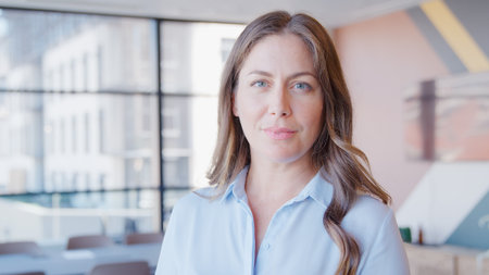 Portrait Of Serious Mature Businesswoman Standing In Empty Office