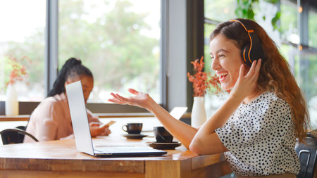 Young Businesswoman With Coffee Making Video Call On Laptop In Coffee Shop