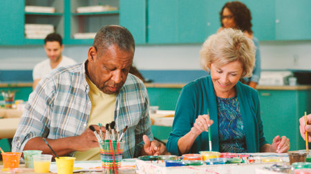 Group Of Retired Seniors Attending Art Class In Community Centre With Teacher