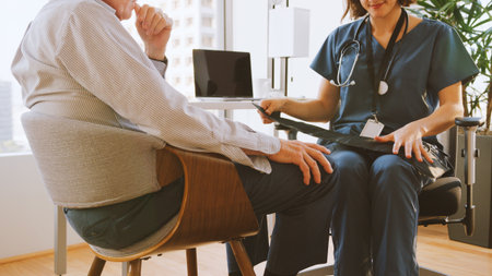 Close Up Of Nurse Wearing Scrubs In Hospital Office Checking Senior Male Patients Blood Pressureの写真素材