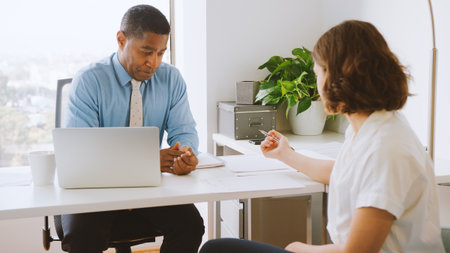 Woman Meeting With Male Financial Advisor In Office And Signing Contract