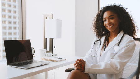 Portrait Of Smiling Female Doctor Wearing White Coat With Stethoscope In Hospital Officeの写真素材