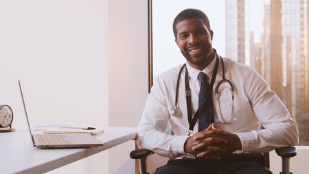 Portrait Of Smiling Male Doctor With Stethoscope In Hospital Officeの写真素材