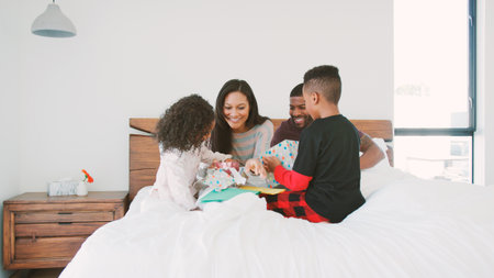 Children In Bed With Parents Celebrating Mother's Day Father's Day Or Birthday With Card And Gift