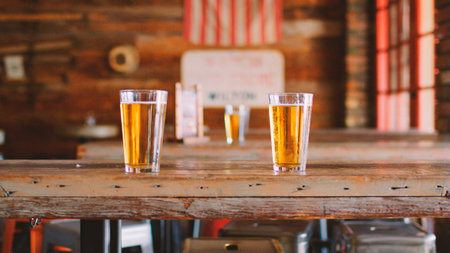 Glasses Of Beer On Table In Empty American Sports Barの写真素材