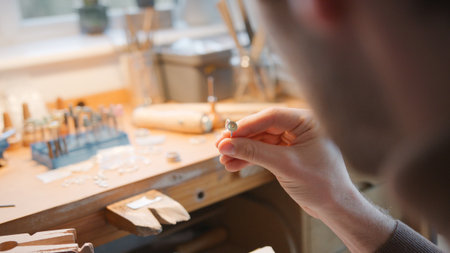 Close Up Of Male Jeweller Looking At Setting For Ring In Studioの写真素材