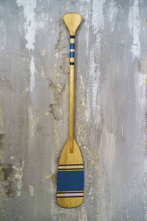 A well-detailed shot of a concrete wall with some texture to use as a background image or a texture for 3D rendering. A wooden paddle hung on itの写真素材