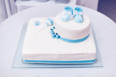 Blue cake with baby shoes in the topの写真素材