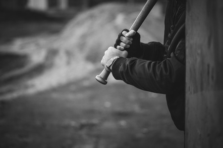 hooligan with the baseball bat in hands ready to attack from hidingの写真素材