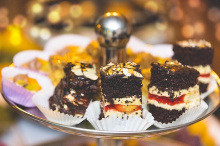 Piece of cakes lying on the metal plate at the buffet tableの写真素材