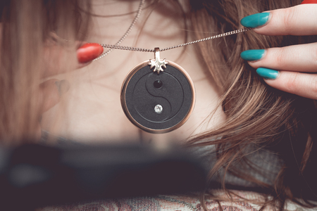Chakra medallion hanging on the woman's neckline, made of alloy of many minerals, piece of meteorite and golden frame.の写真素材