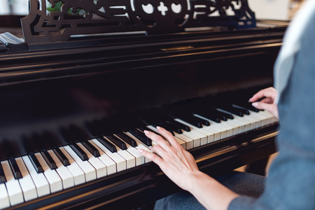 Girl playing on black pianoの写真素材