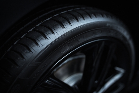 Closeup of new black tire of sport car with reflection on the edge, visible new treadの写真素材