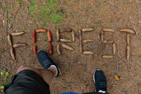 Human killing the forest. Word forest made by cone on the ground