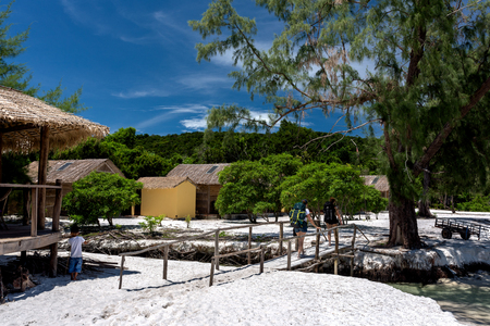 Tourists passing through the bridge, small Cambodian boy playing with the stick close to the bungalow. Koh Rong Samloem island, Saracen Bay. Cambodia, Asia. 08 September 2017のeditorial素材