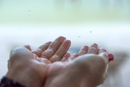 Rain drops falling on woman's hand