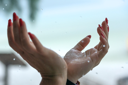 Rain drops falling on woman's handの写真素材