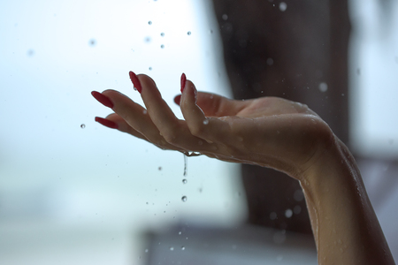Rain drops falling on woman's handの写真素材