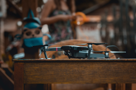 Modern professional quadro drone in wooden table ready for use.