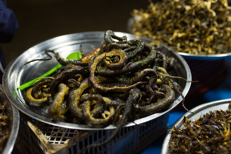 Cambodian night street food market with grilled snakes in the iron bowlの写真素材