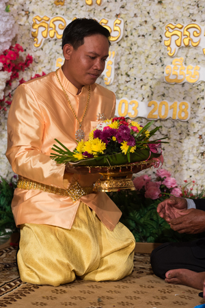 Groom thanks to bride and mother kneeling in front of them. Kampot 07 july 2018, Cambodia.のeditorial素材