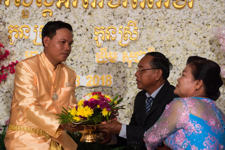 Groom thanks to bride and mother kneeling in front of them. Kampot 07 july 2018, Cambodia.のeditorial素材