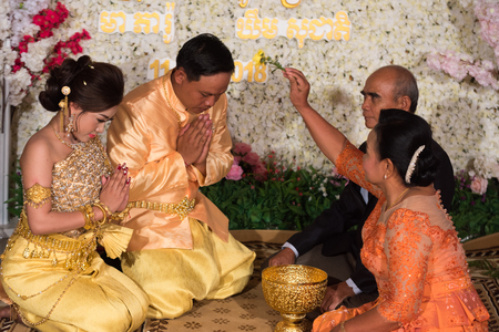 The fiancee couple thank you for their parents kneeling in front of them. Kampot 07 july 2018, Cambodia.のeditorial素材