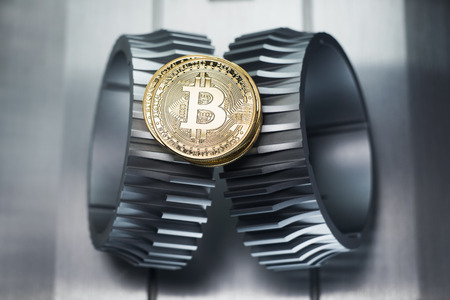 Golden bitcoin lies on the metal gearwheel. Digital Crypto currency revolution.の写真素材