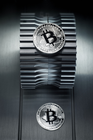 Silver bitcoin lies on the metal gearwheel. Digital Crypto currency revolution.の写真素材