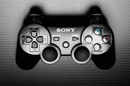 DualShock 3 wireless controller, a gamepad for the PlayStation 3, a home video game console produced by Sony Computer Entertainment, on dark background. Wroc?aw, 16 February 2012, Poland.のeditorial素材