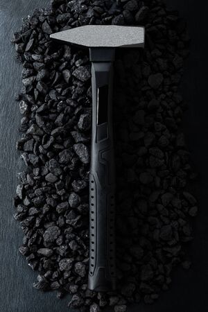 Professional reinforced black matt locksmith hammer placed on a stony background. View from the top.の写真素材